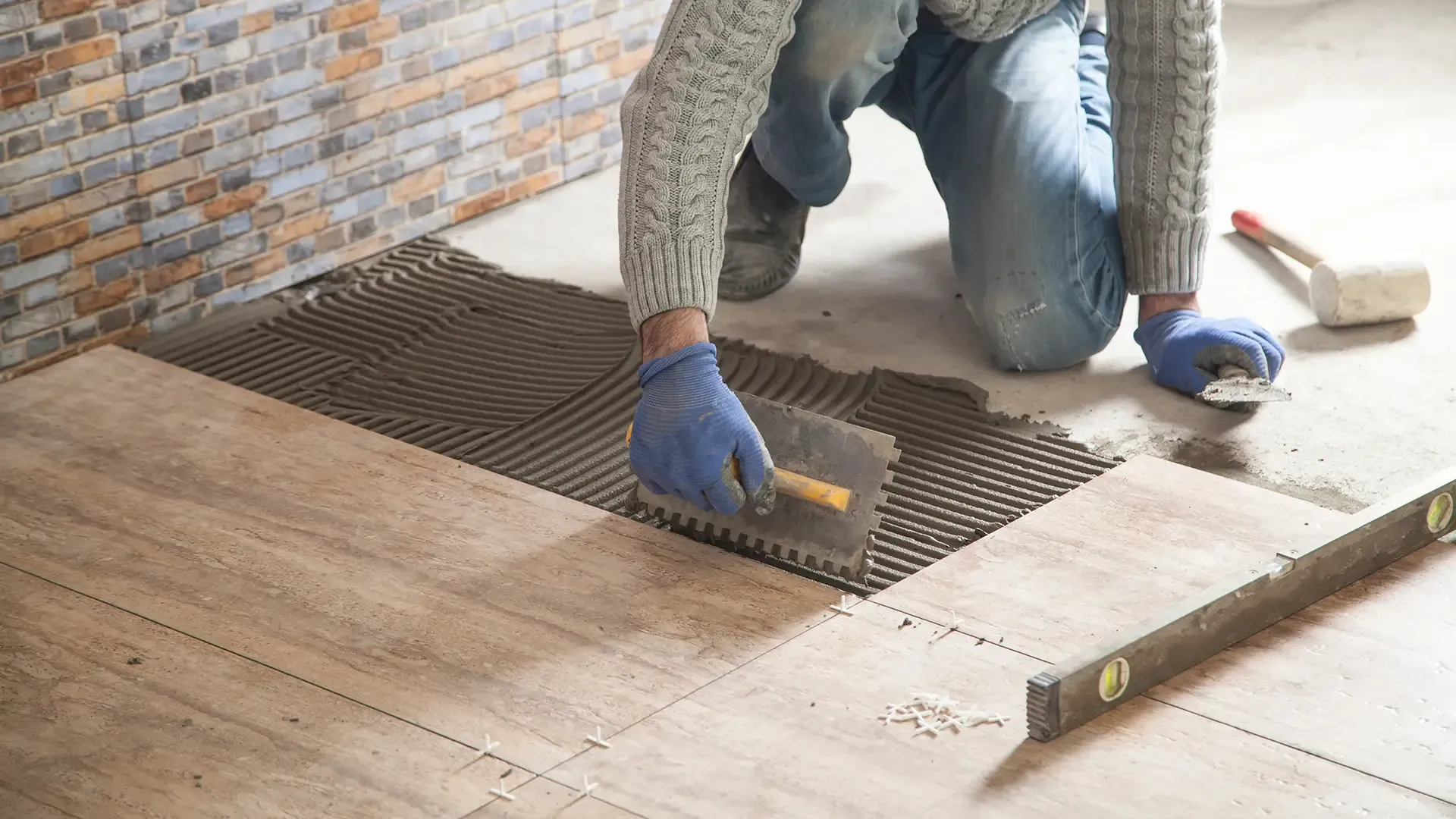 Installer setting floor tile with a trowel in Fort Myers