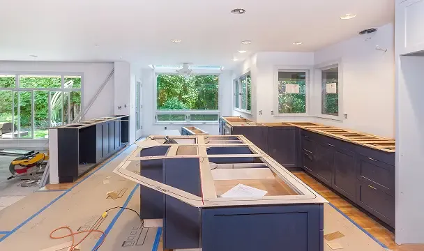 Kitchen remodel in progress with new cabinets and windows